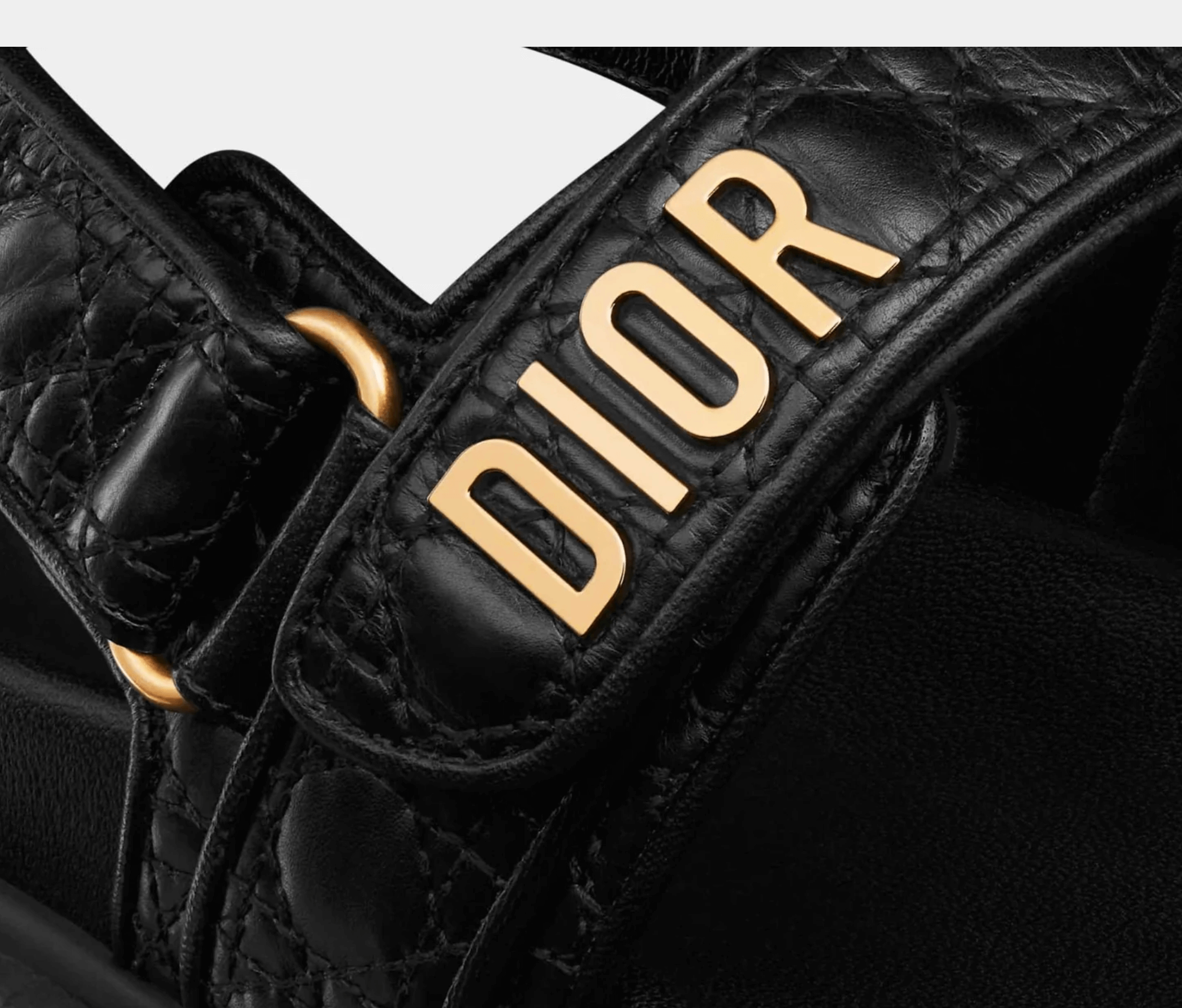 Close-up of gold-tone DIOR signature on quilted leather upper and tonal stitching detail
