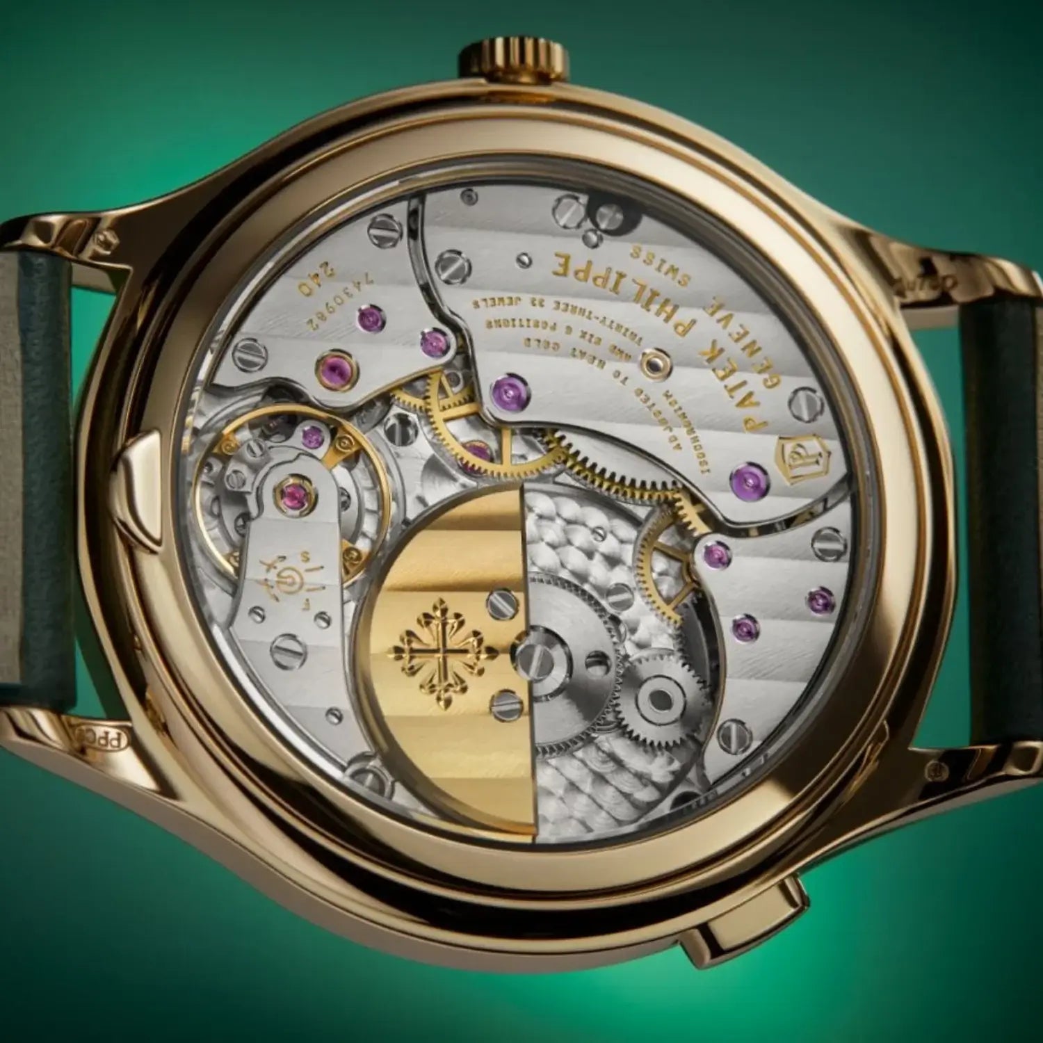 Close-up of a gold watch with visible mechanical components on a green background