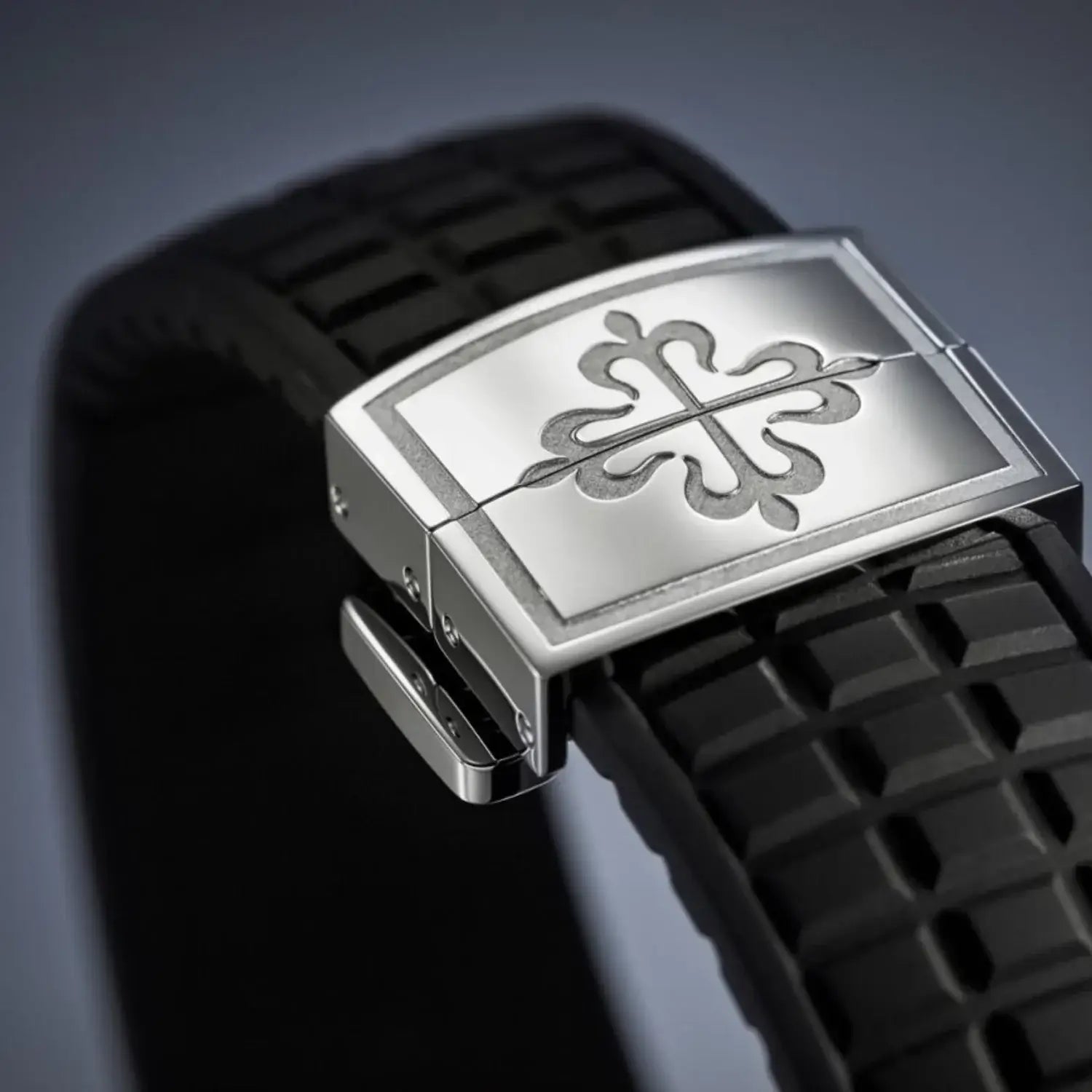 Close-up of a watch with a decorative metal buckle on a dark background